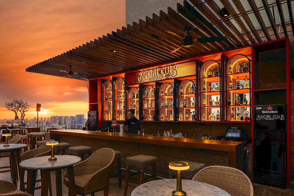 The glowing gold-lit bar invites guests to watch the finesse of skilled bartenders up close